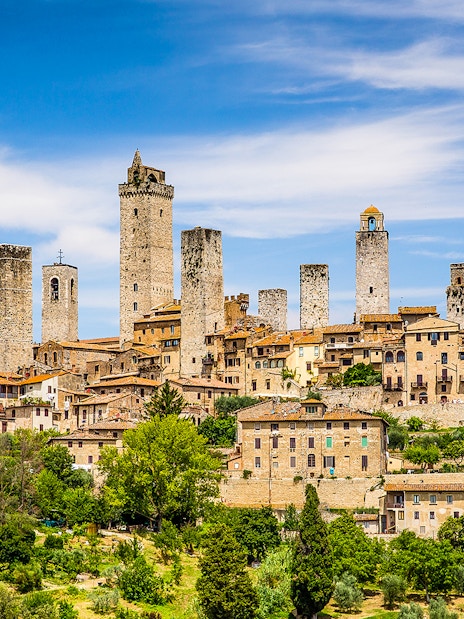San Gimignano skyline with medieval towers under a blue sky, Tuscany, Italy.
