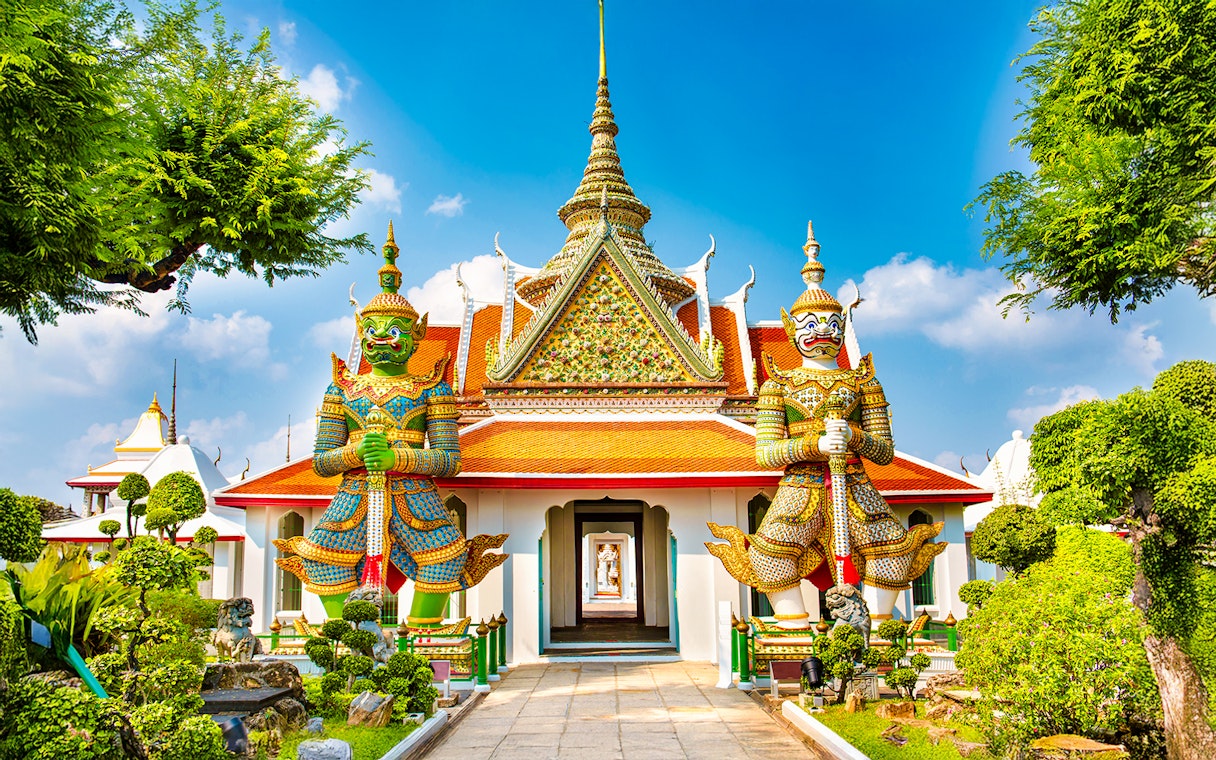 Wat Arun entrance with guardian statues, Bangkok.