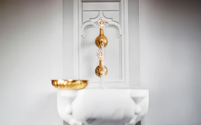 Golden taps and marble basin in Hurrem Sultan Hamam, Istanbul.