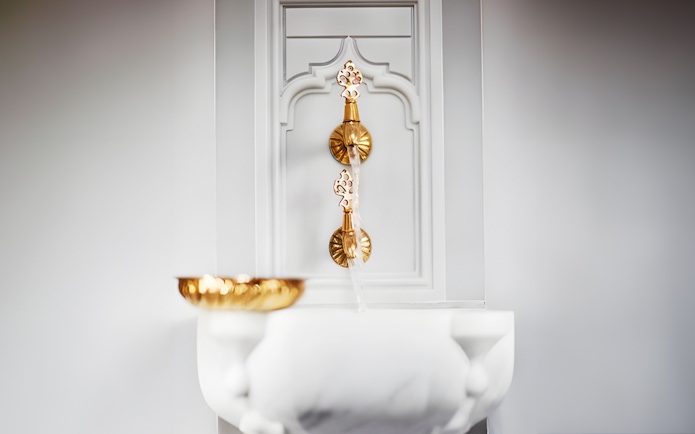 Golden taps and marble basin in Hurrem Sultan Hamam, Istanbul.