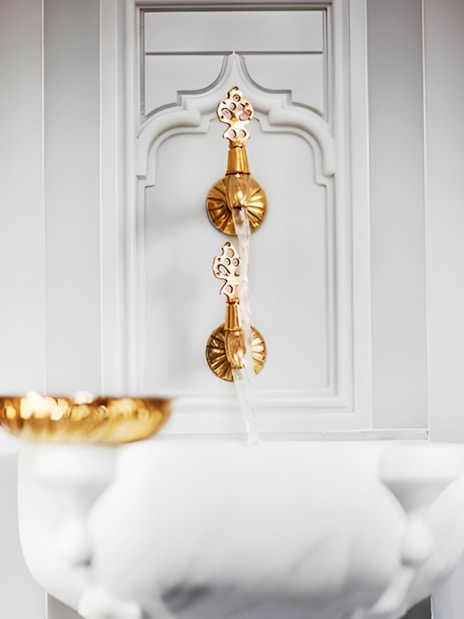 Golden taps and marble basin in Hurrem Sultan Hamam, Istanbul.