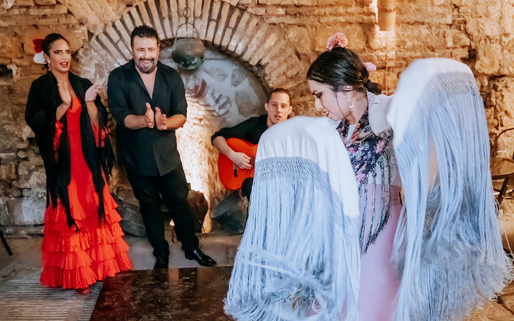 Flamenco performance at Tablao en Baños Árabes de Santa María with dancers and guitarist.