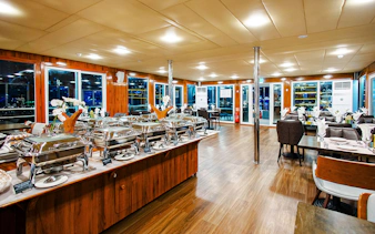 Dinning area setup on Alexandra Sea Lounge Dhow Cruise with buffet and seating.