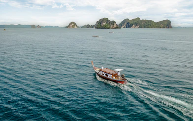 Longtail boat sailing near limestone islands in Krabi, Thailand.