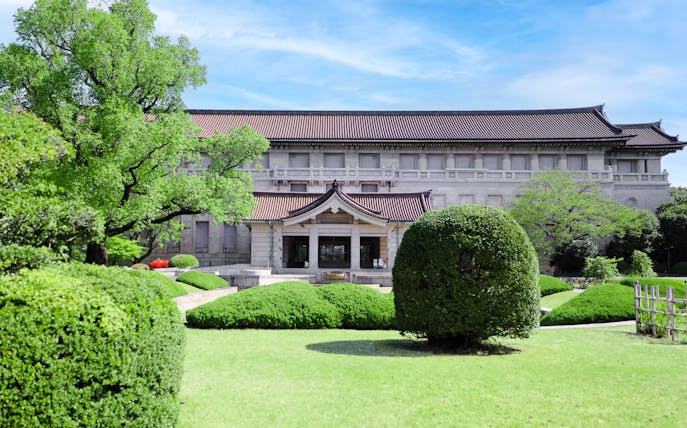 Tokyo National Museum main building with lush garden and traditional architecture.