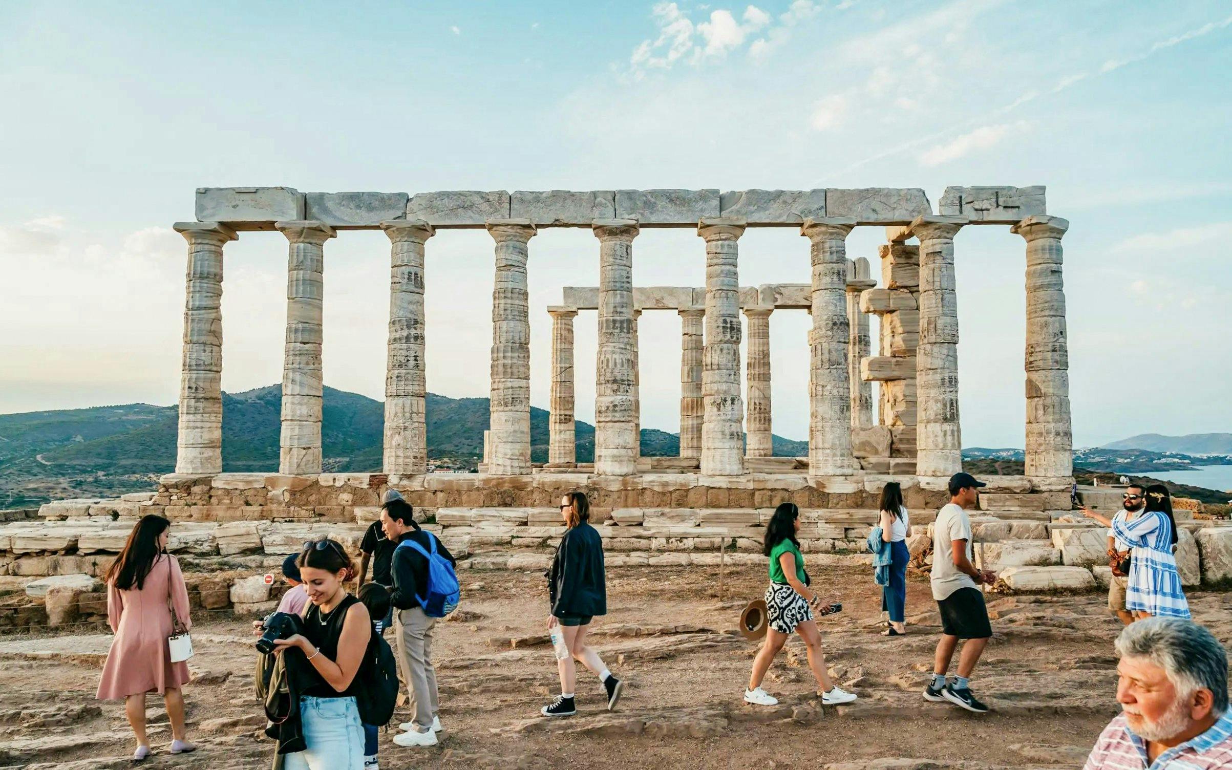 Visitors exploring the Temple of Poseidon at Cape Sounion during a private tour.