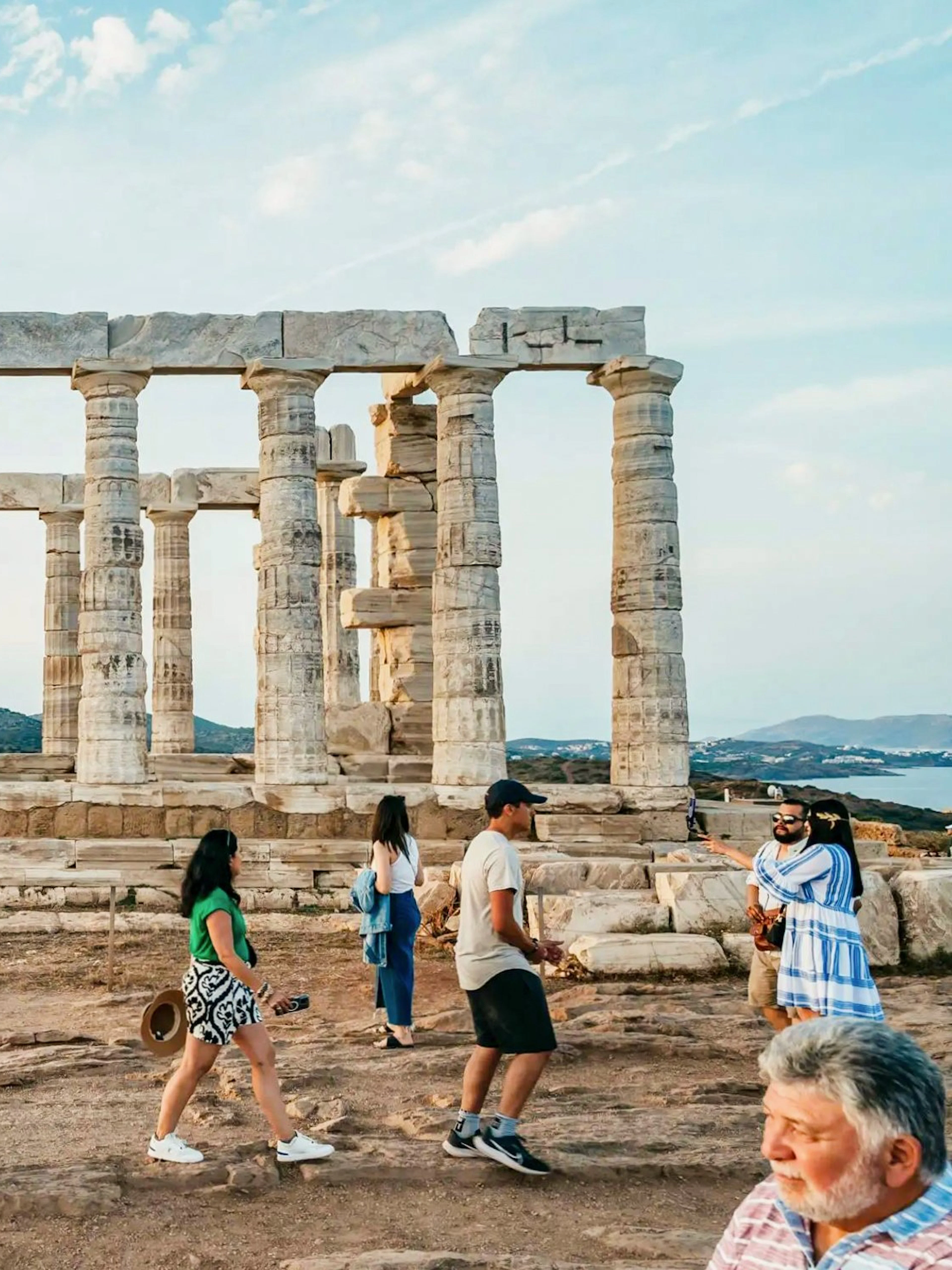 Visitors exploring the Temple of Poseidon at Cape Sounion during a private tour.