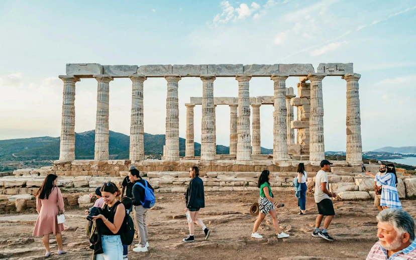 Visitors exploring the Temple of Poseidon at Cape Sounion during a private tour.