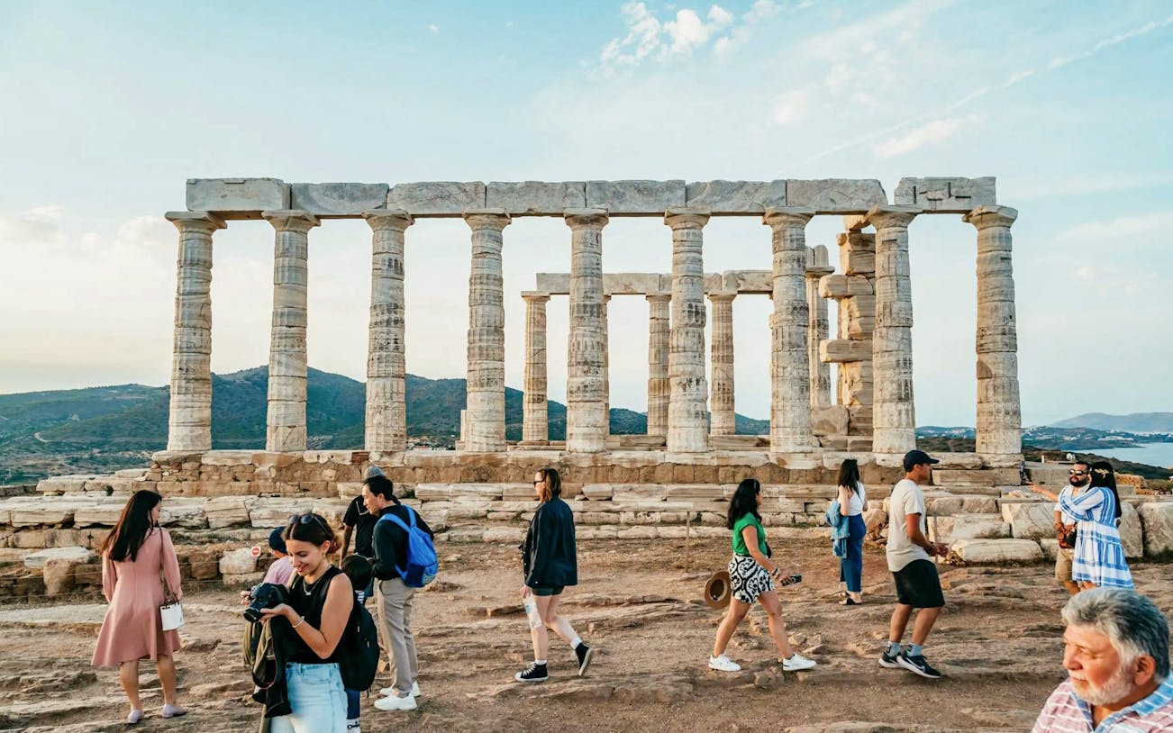 Visitors exploring the Temple of Poseidon at Cape Sounion during a private tour.