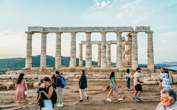 Visitors exploring the Temple of Poseidon at Cape Sounion during a private tour.