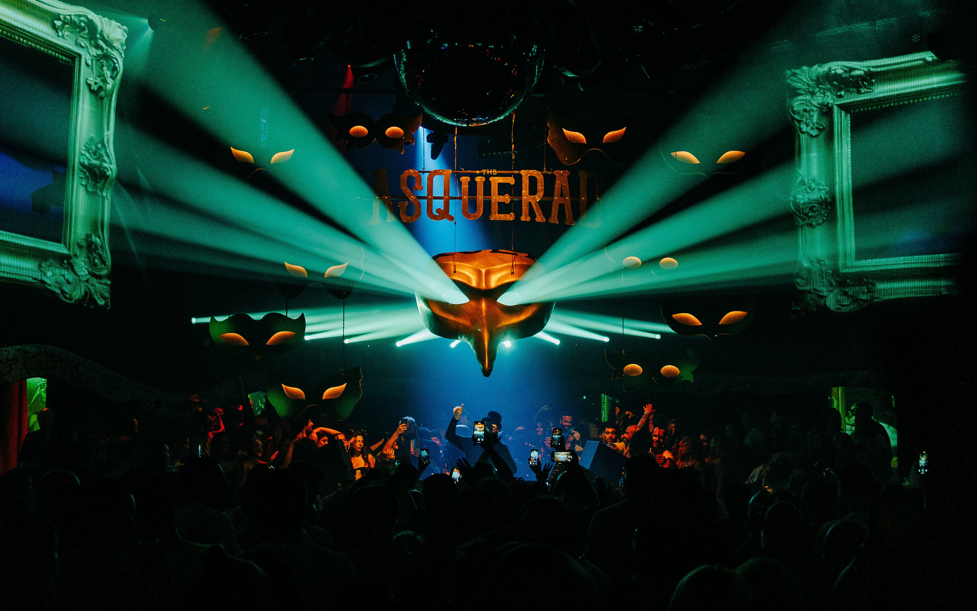 DJ performing at Club Chinois with vibrant lights and crowd, Ibiza.