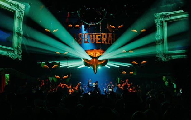 DJ performing at Club Chinois with vibrant lights and crowd, Ibiza.