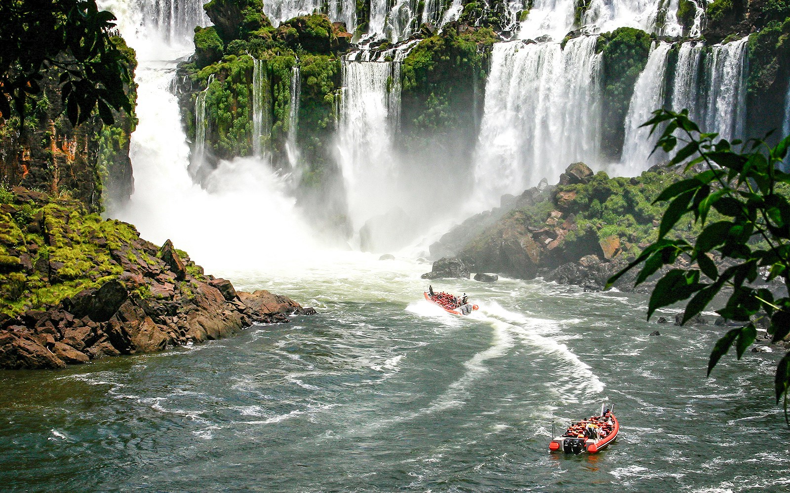Speed boat rides under the water cascading over the Iguacu falls in Brazil