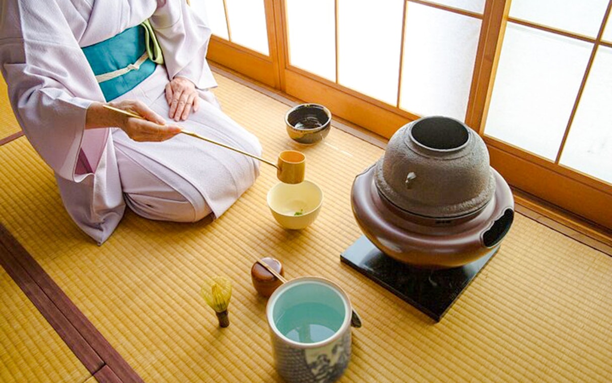 Person in kimono preparing matcha tea in traditional Japanese room, Tokyo.