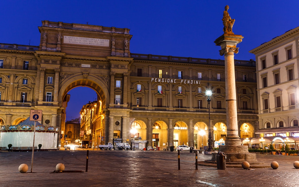 Republic Square in Florence at night with illuminated arch and column.