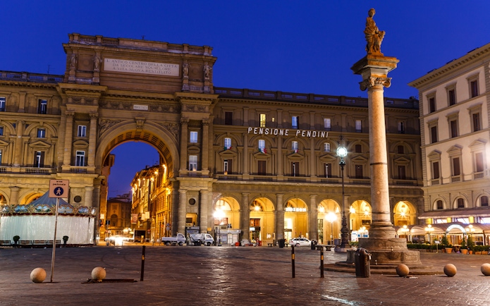 Republic Square in Florence at night with illuminated arch and column.
