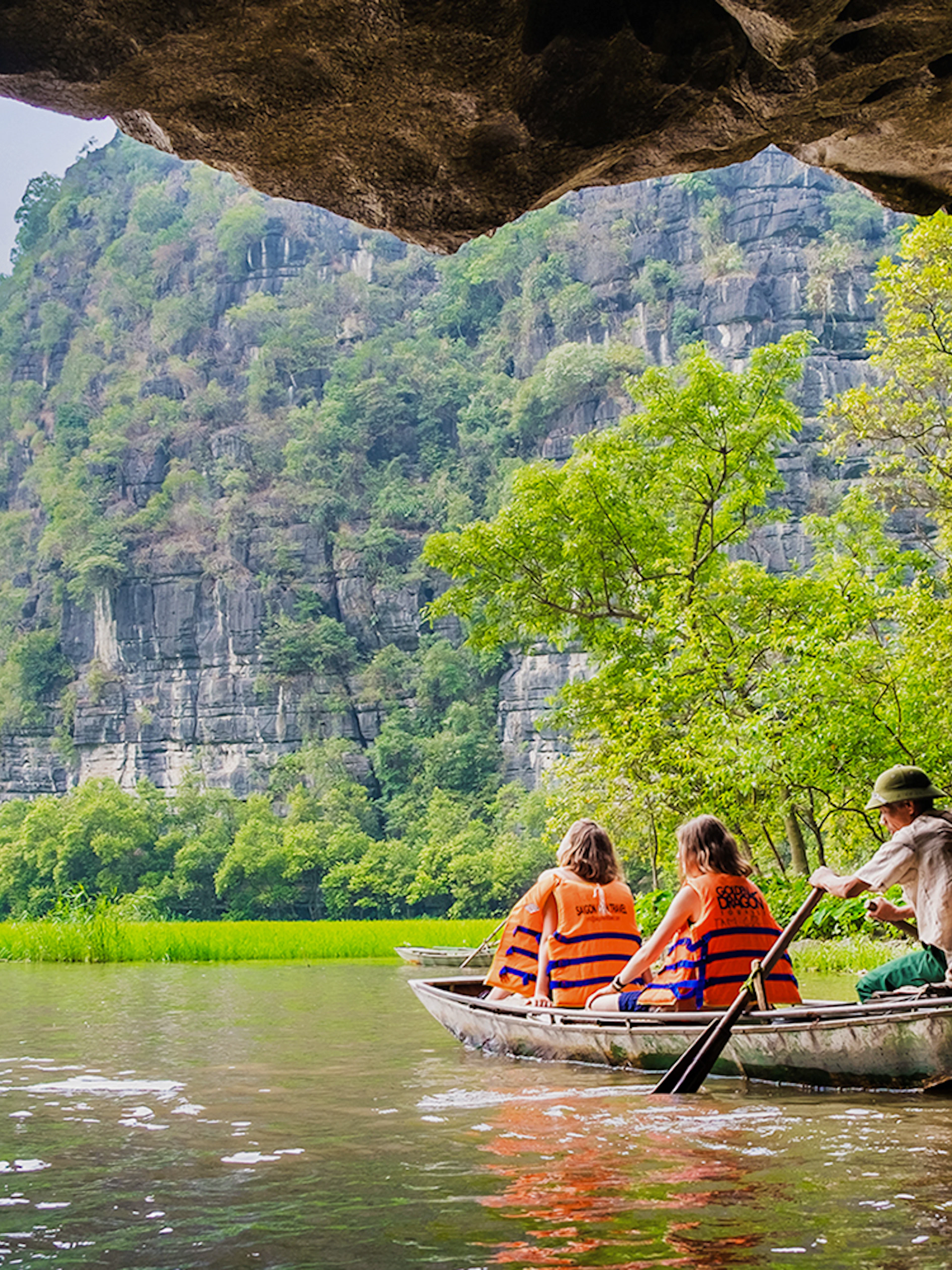 Boating through limestone caves and lush greenery in Tam Coc, Vietnam.