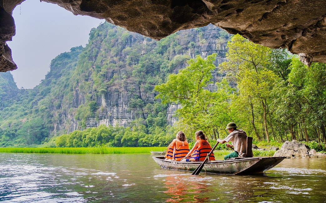 Boating through limestone caves and lush greenery in Tam Coc, Vietnam.