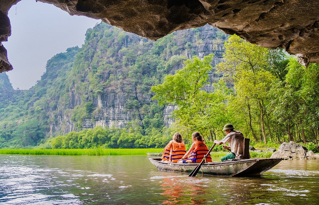 Boating through limestone caves and lush greenery in Tam Coc, Vietnam.