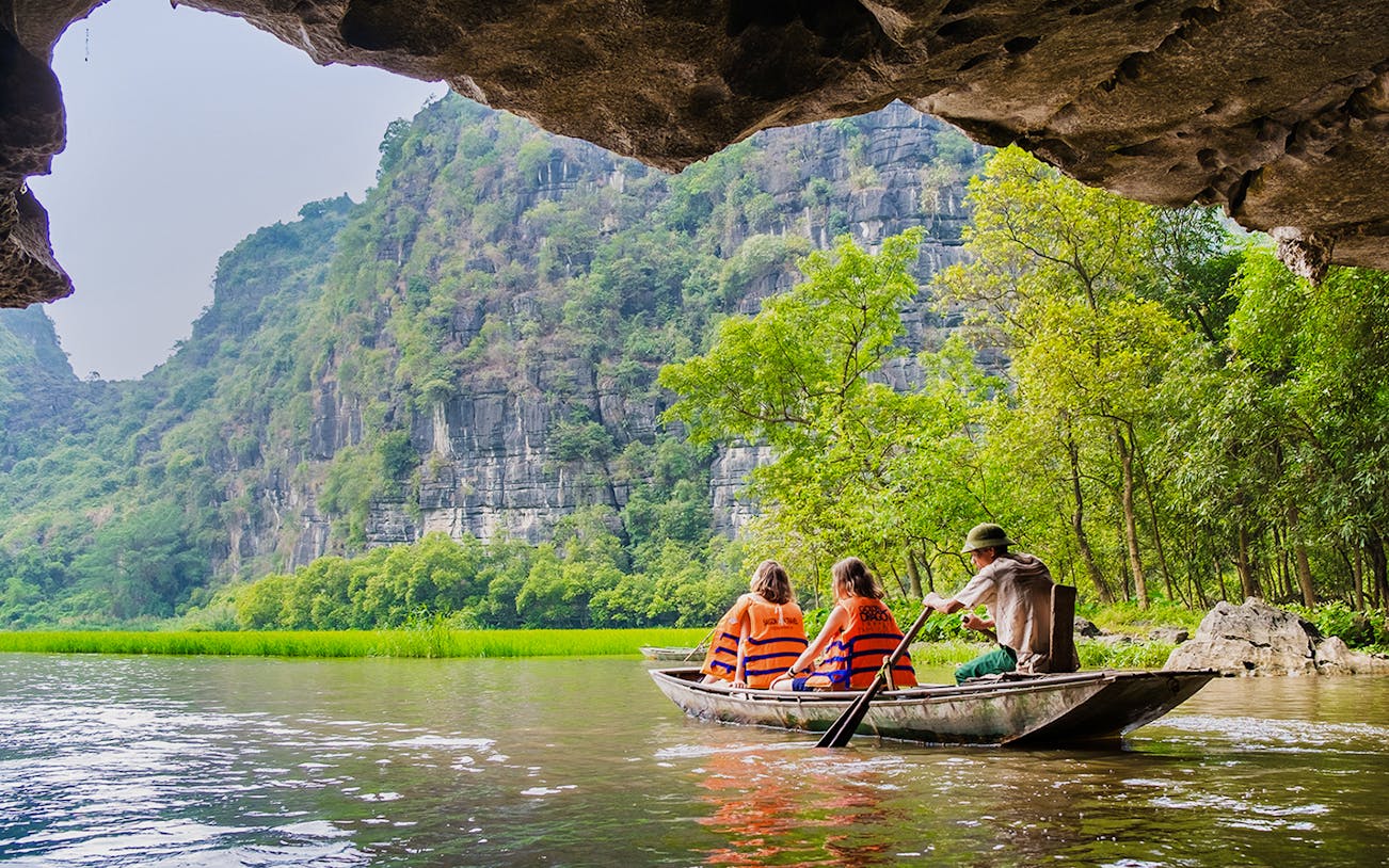 Boating through limestone caves and lush greenery in Tam Coc, Vietnam.