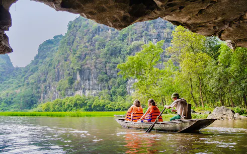 Boating through limestone caves and lush greenery in Tam Coc, Vietnam.