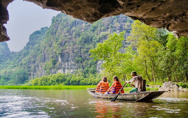 Boating through limestone caves and lush greenery in Tam Coc, Vietnam.