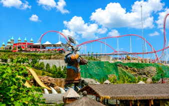 Vialand Theme Park Istanbul with roller coaster and giant statue.