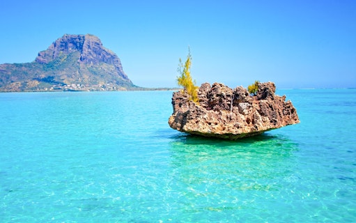Crystal rock formation in turquoise waters with Le Morne Brabant in the background, Mauritius.