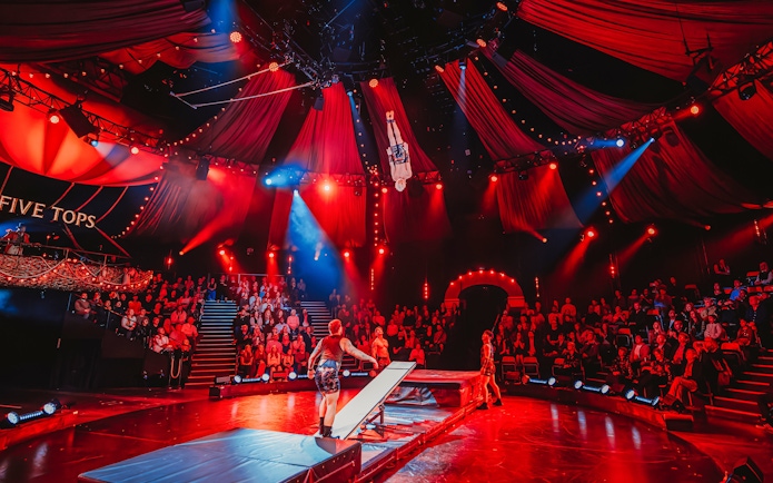 Acrobat performing mid-air flip during Come Alive Westend stage show.