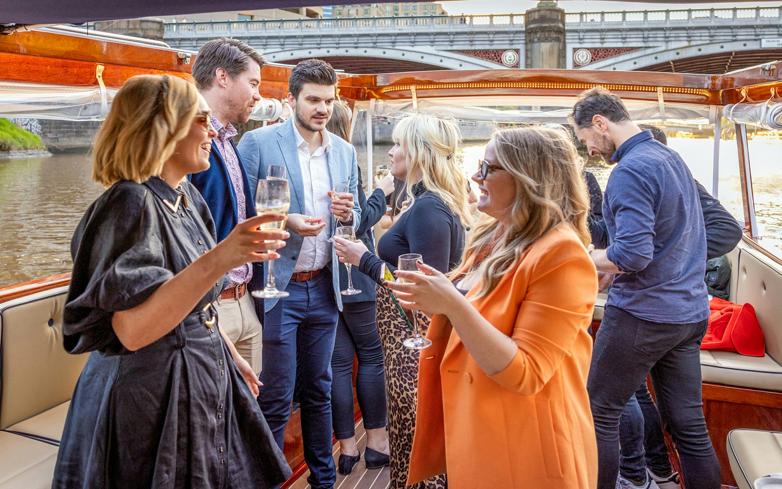 Passengers on a Yarra River sunset cruise in Melbourne, viewing city skyline.