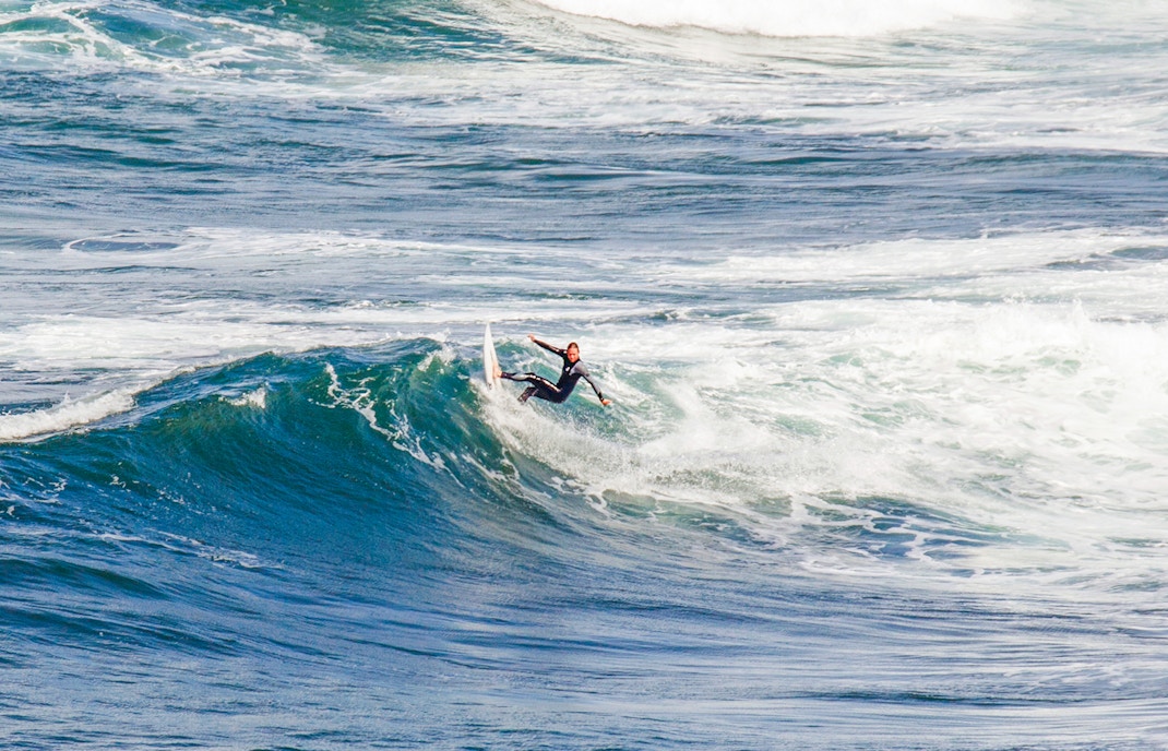 Surfer riding waves at Bells Beach, Australia.
