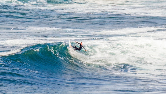 Surfer riding waves at Bells Beach, Australia.