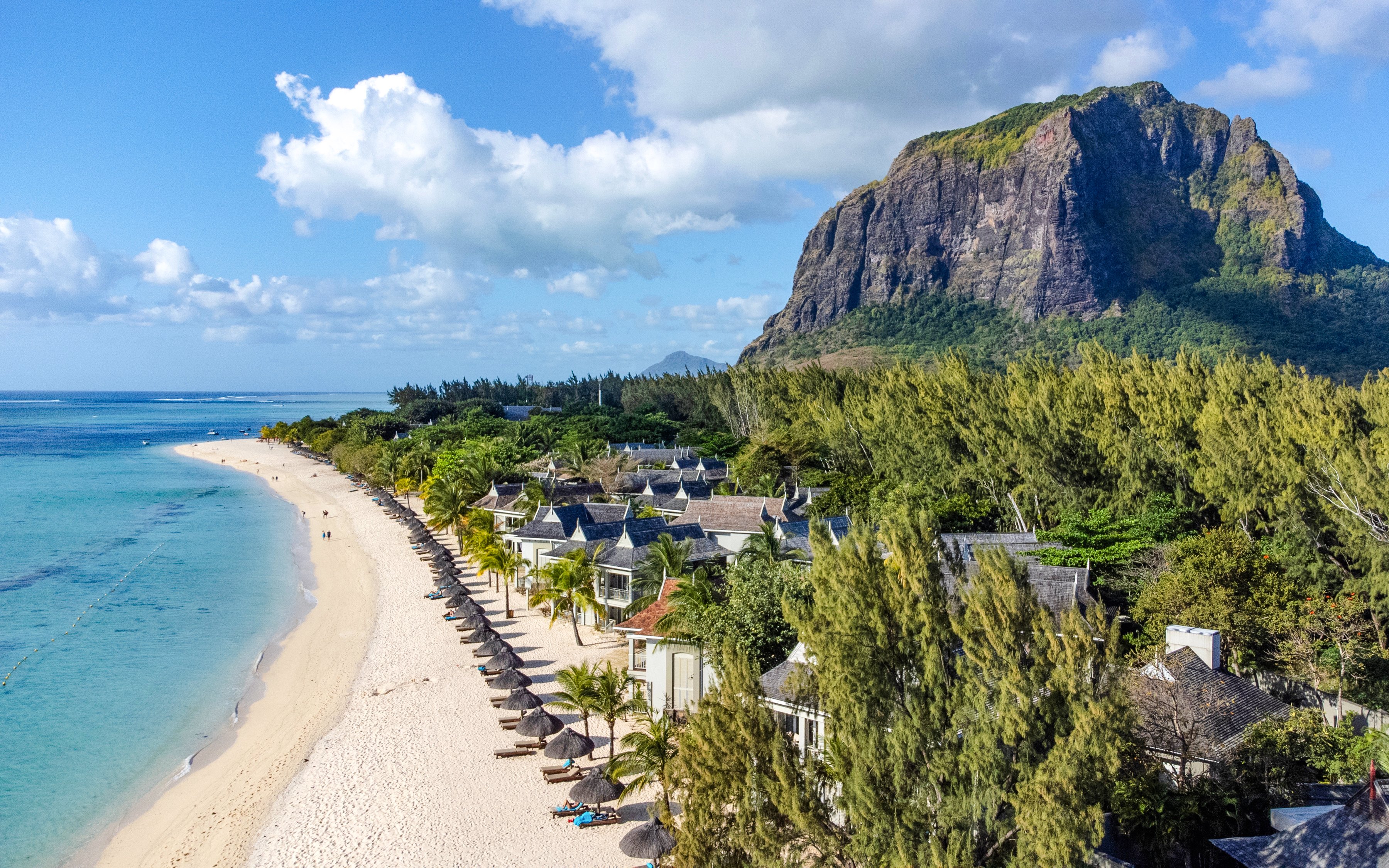 Le Morne Beach in Mauritius with mountain backdrop and beachfront villas.
