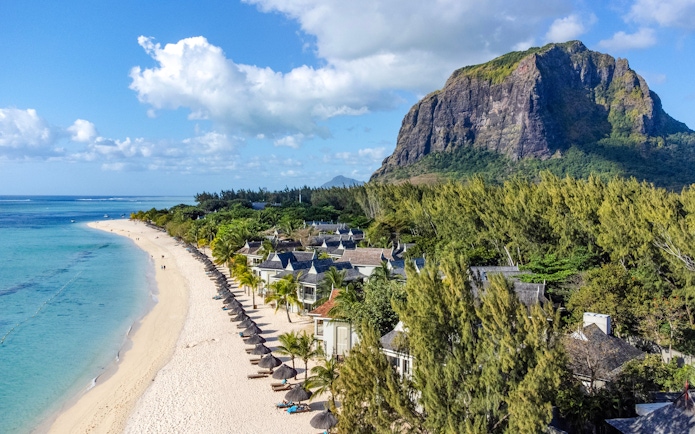 Le Morne Beach in Mauritius with mountain backdrop and beachfront villas.