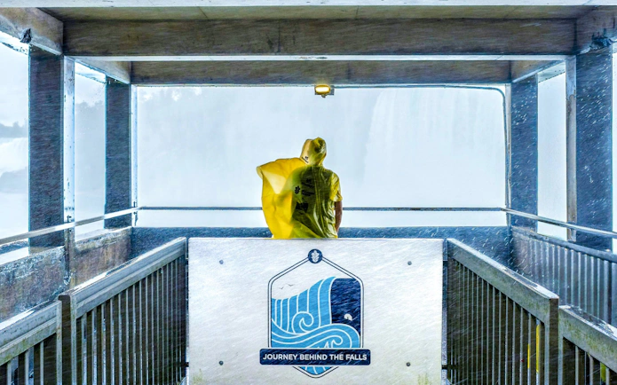 Visitor in yellow poncho at Journey Behind the Falls platform, Niagara Falls, Canada.