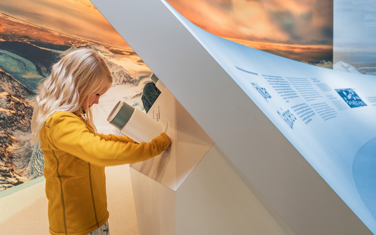 Child exploring interactive exhibit at Perlan's Wonders of Iceland.