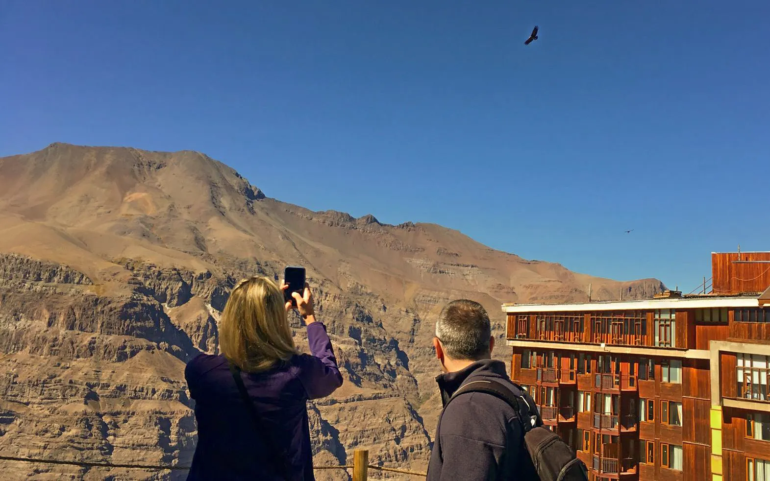 Visitors photographing Andes Mountains near Santiago, Chile.