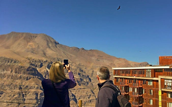 Visitors photographing Andes Mountains near Santiago, Chile.