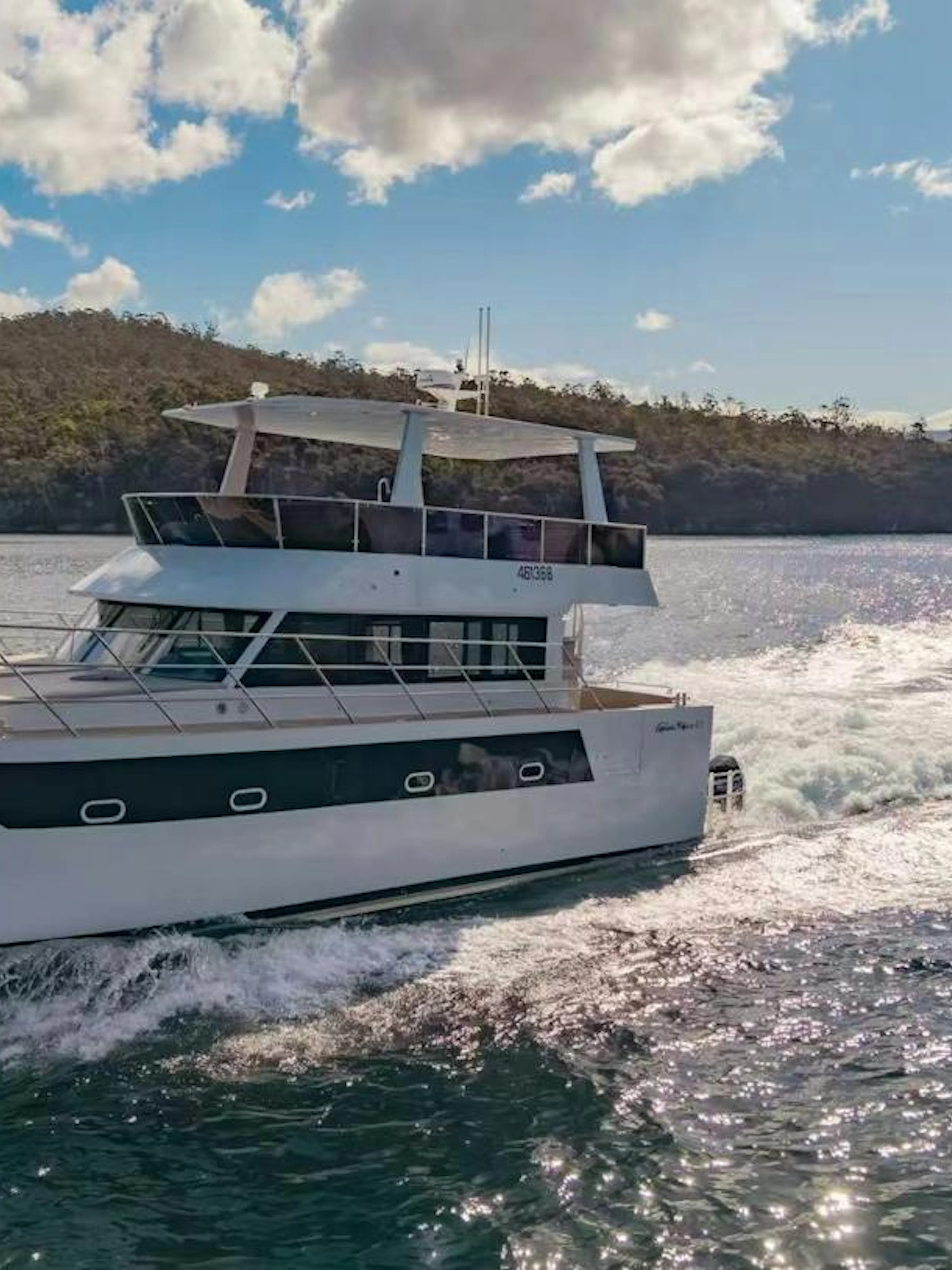 Cruise boat on Hobart waters with scenic coastline in background.