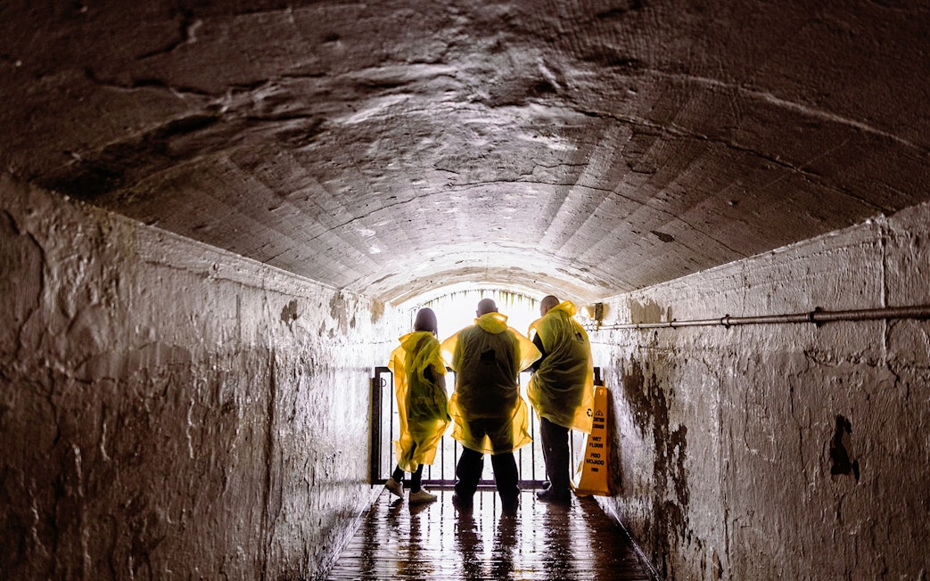 Visitors in yellow ponchos in a tunnel at Journey Behind the Falls, Niagara Falls.