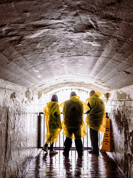 Visitors in yellow ponchos in a tunnel at Journey Behind the Falls, Niagara Falls.