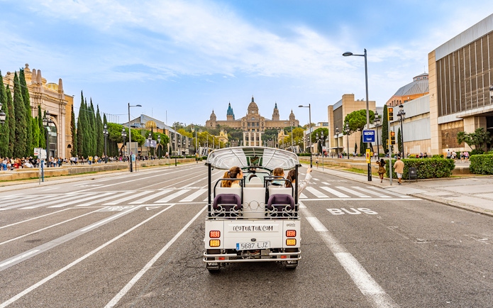 Tuk tuk driving towards the National Palace in Barcelona.