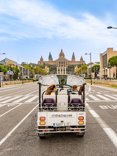 Tuk tuk driving towards the National Palace in Barcelona.