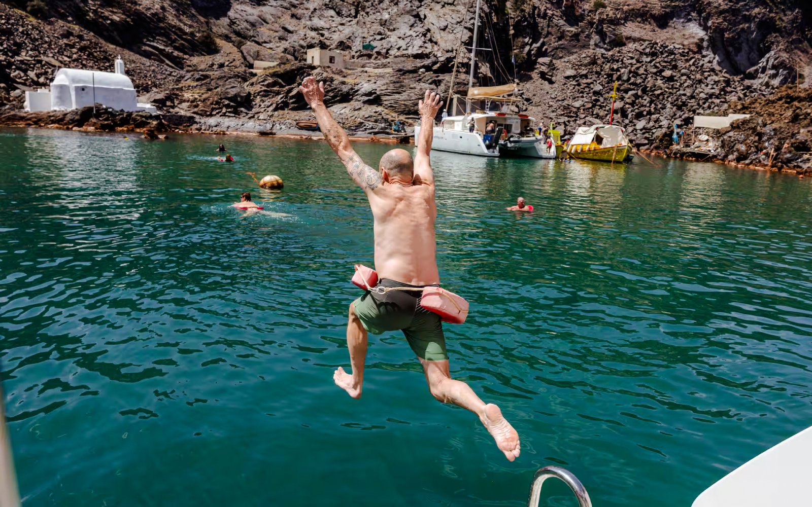 Guests swimming and jumping into the sea during Classic Catamaran Cruise tour.