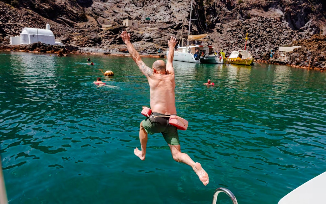 Guests swimming and jumping into the sea during Classic Catamaran Cruise tour.