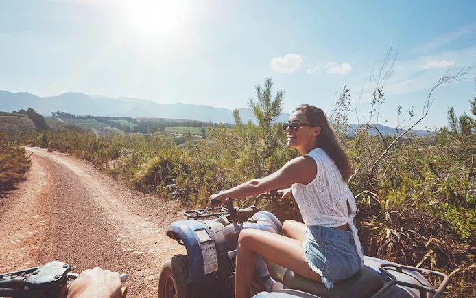 Quad biking on a dirt trail with scenic mountain views in Antalya.