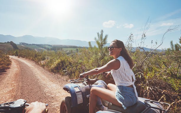 Quad biking on a dirt trail with scenic mountain views in Antalya.