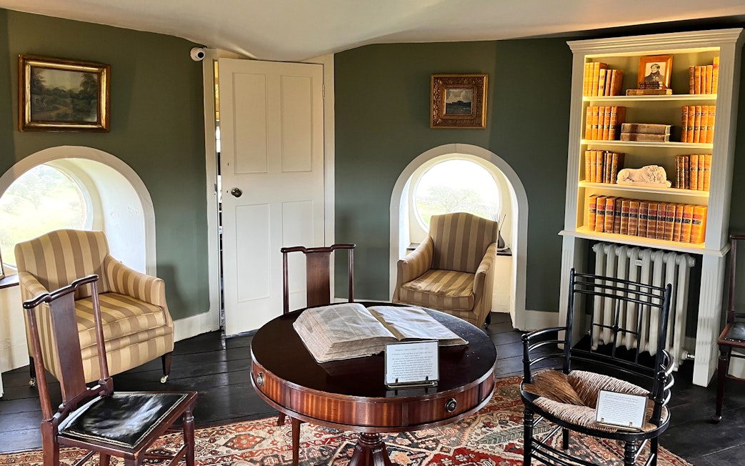 Interior of Broadway Tower with vintage furniture and bookshelves, Cotswolds tour from London.