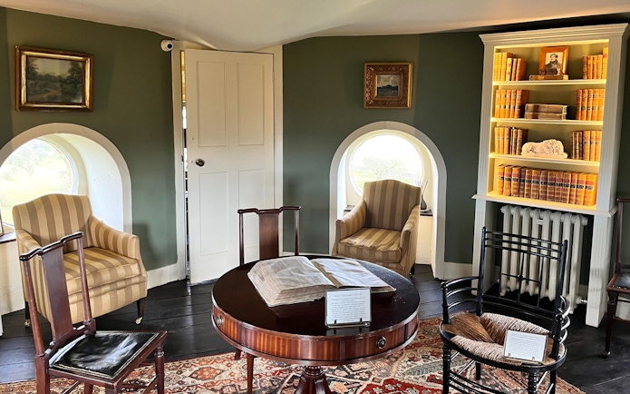 Interior of Broadway Tower with vintage furniture and bookshelves, Cotswolds tour from London.