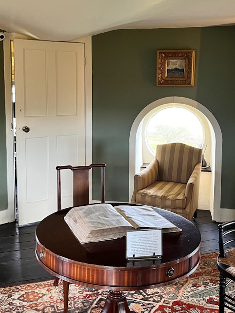 Interior of Broadway Tower with vintage furniture and bookshelves, Cotswolds tour from London.